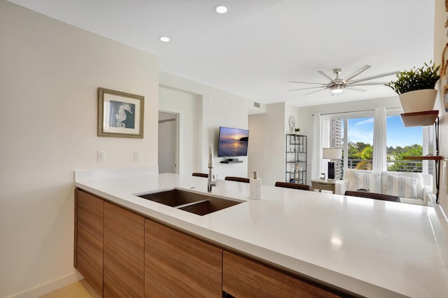 kitchen featuring ceiling fan and sink