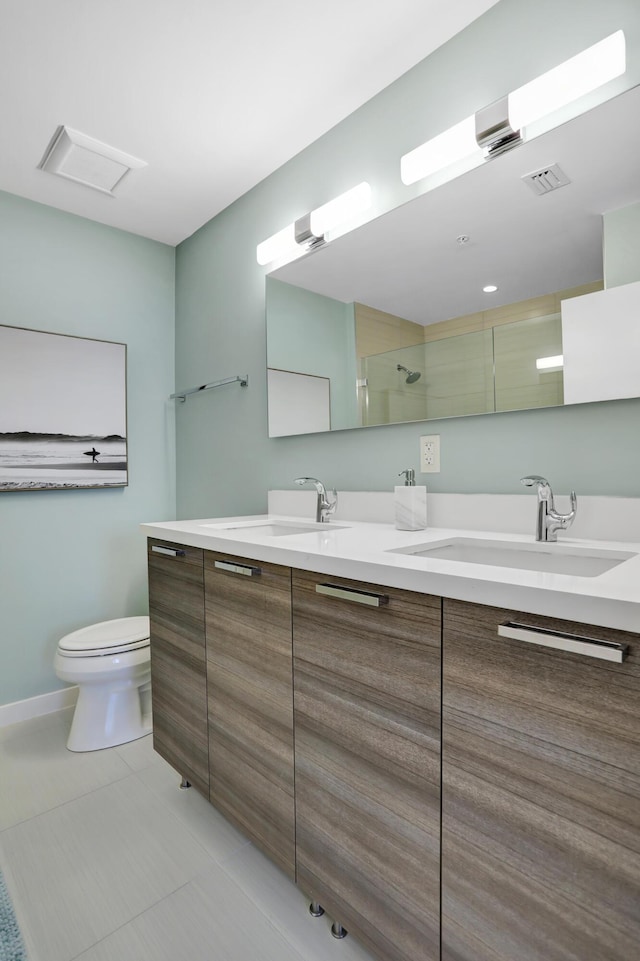 bathroom with tile patterned flooring, vanity, toilet, and walk in shower