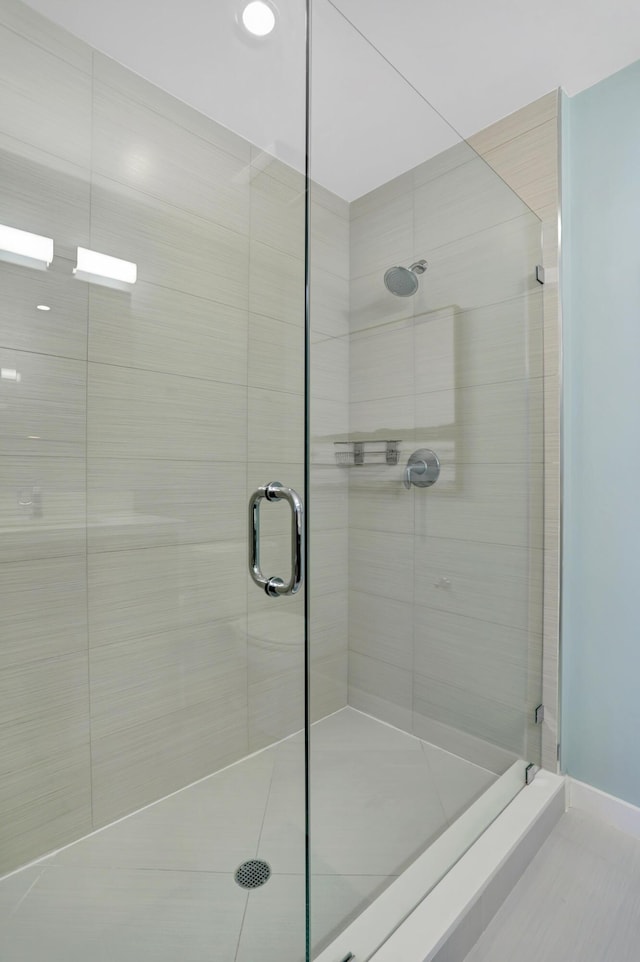 bathroom featuring tile patterned flooring and a shower with shower door