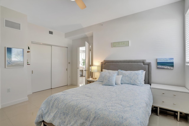 bedroom with ceiling fan, light tile patterned floors, and a closet