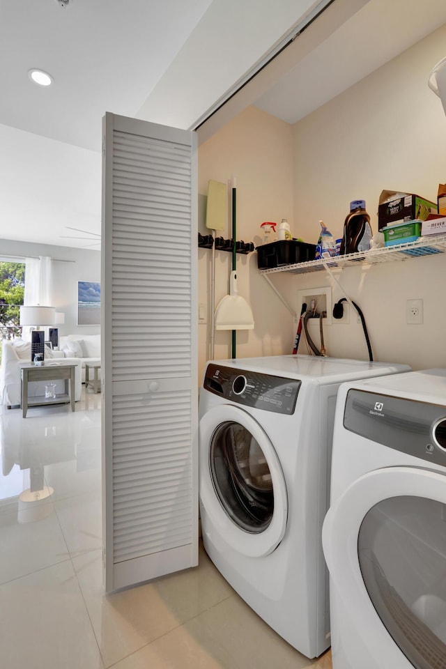 laundry room with independent washer and dryer and light tile patterned flooring