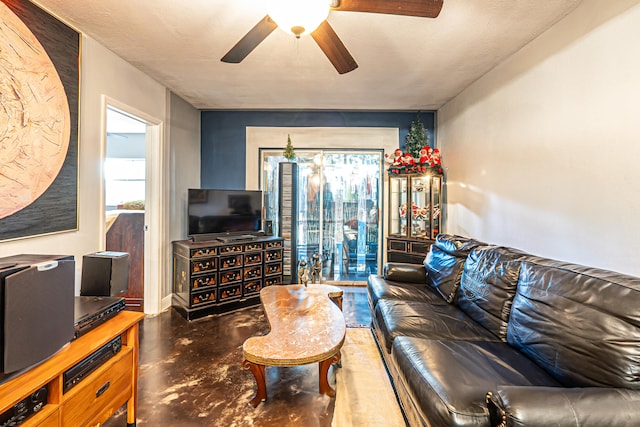 living room featuring ceiling fan and a textured ceiling