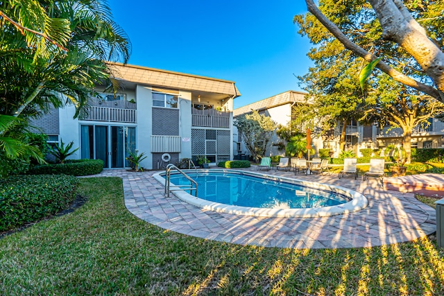 view of pool featuring a lawn and a patio area