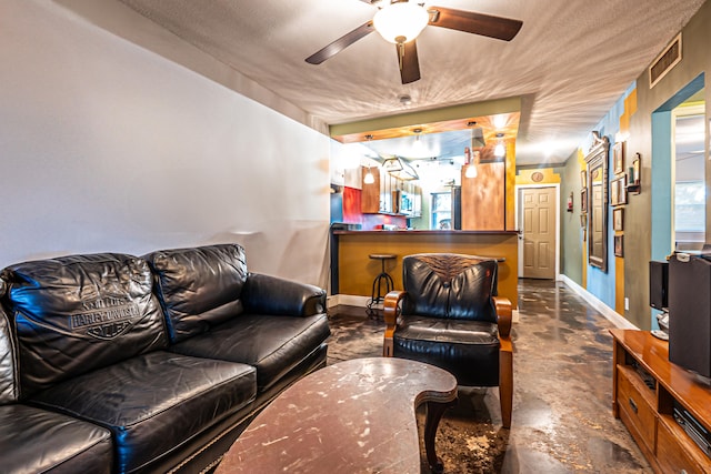 living room featuring concrete flooring, a textured ceiling, and ceiling fan