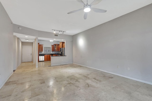 unfurnished living room featuring rail lighting, baseboards, and a ceiling fan