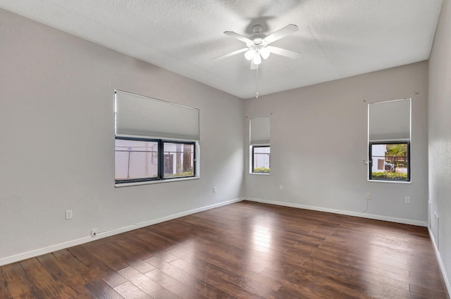 unfurnished room featuring ceiling fan, dark wood-type flooring, and a textured ceiling