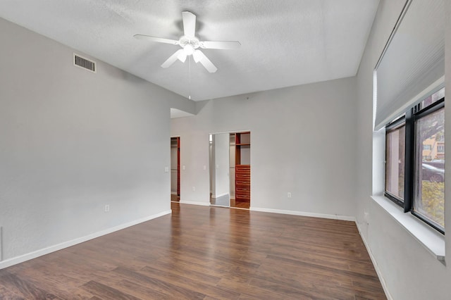 empty room featuring ceiling fan, dark hardwood / wood-style flooring, and a textured ceiling