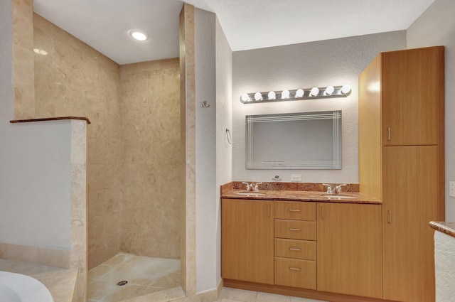 full bathroom featuring vanity, a bath, a textured wall, and tiled shower