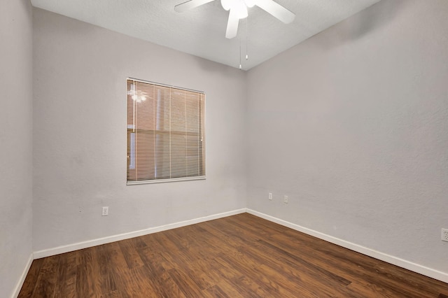 unfurnished room with a ceiling fan, baseboards, and dark wood-style flooring