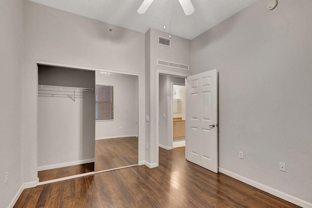 unfurnished bedroom with visible vents, baseboards, a closet, and dark wood-style floors