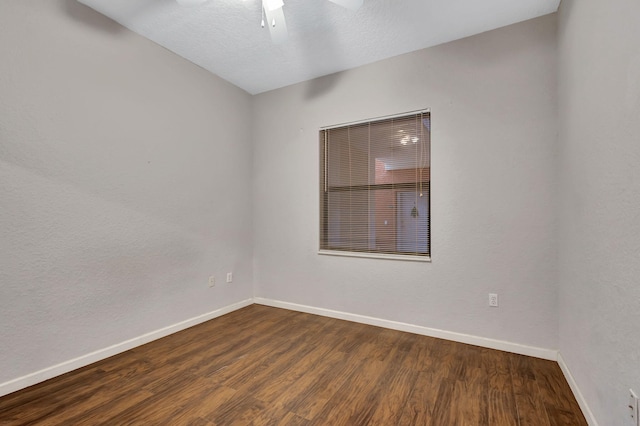 empty room featuring baseboards, wood finished floors, and a ceiling fan