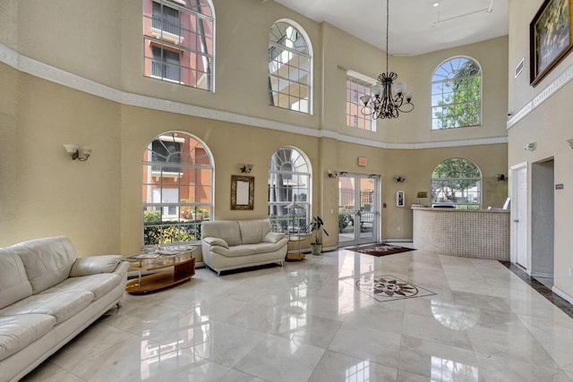 living room with baseboards, plenty of natural light, marble finish floor, and a chandelier