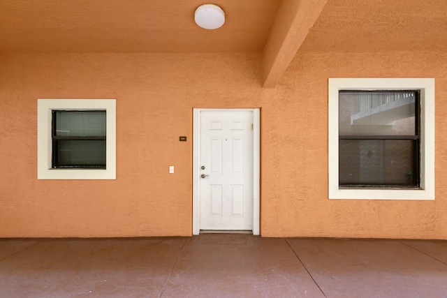 entrance to property featuring stucco siding