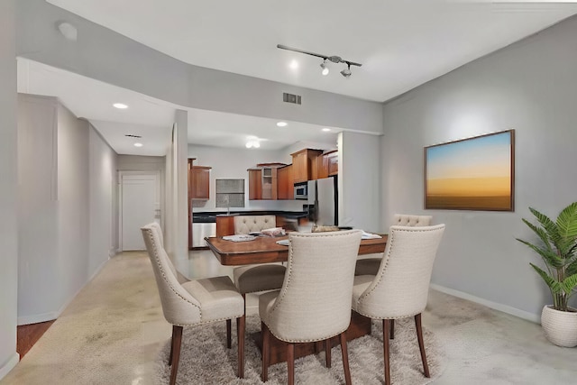 carpeted dining room with track lighting