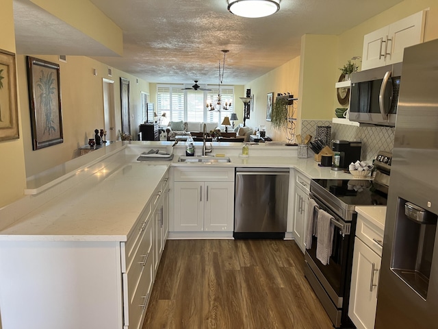 kitchen featuring kitchen peninsula, sink, white cabinets, and appliances with stainless steel finishes