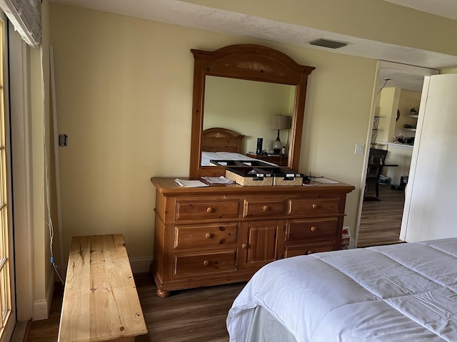 bedroom with dark hardwood / wood-style flooring