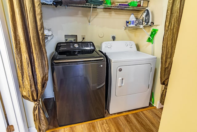 washroom with light wood-type flooring, washer and dryer, and laundry area