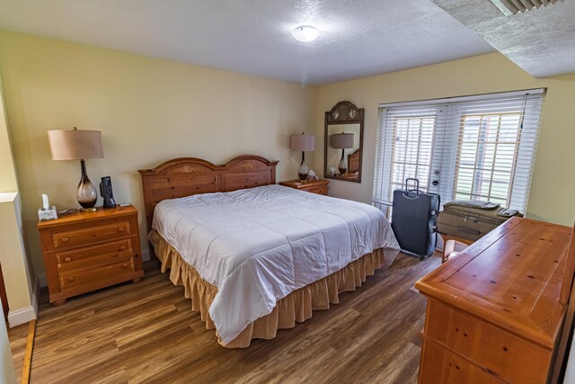 bedroom featuring dark hardwood / wood-style flooring and french doors