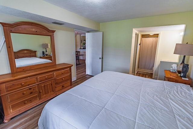 bedroom featuring visible vents and dark wood finished floors