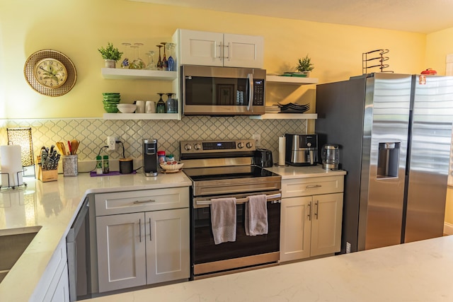 kitchen featuring appliances with stainless steel finishes, tasteful backsplash, light stone countertops, and open shelves