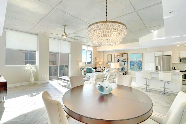 dining room with ceiling fan with notable chandelier