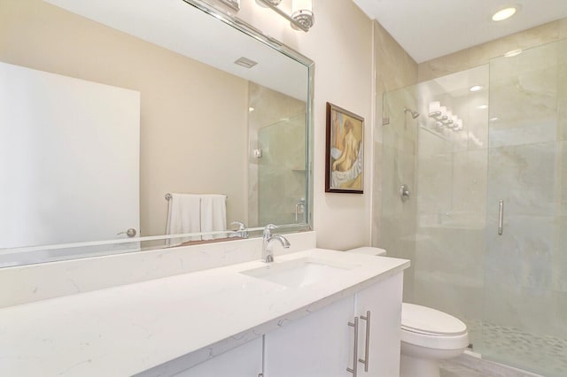 bathroom with vanity, toilet, and a shower with shower door