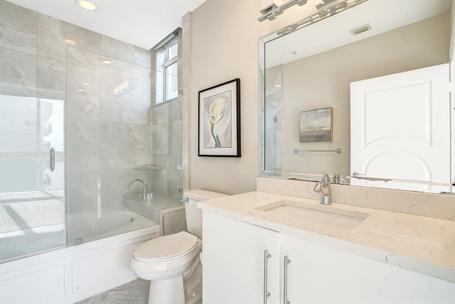 full bathroom featuring shower / bath combination with glass door, vanity, and toilet