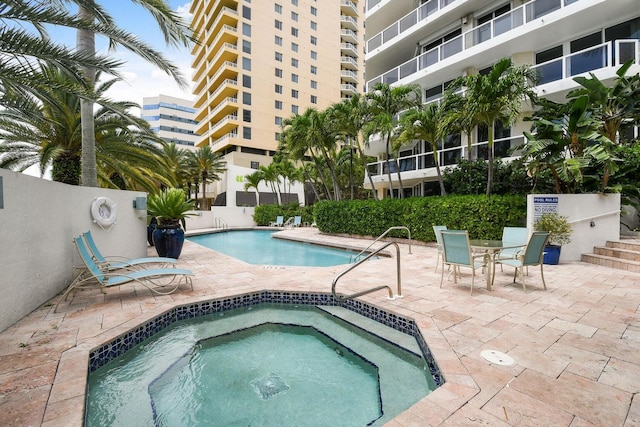 view of pool featuring a hot tub and a patio area