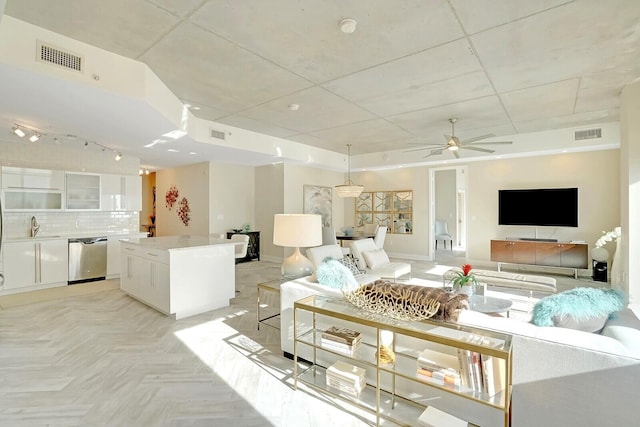 living room with light parquet floors, ceiling fan, and sink