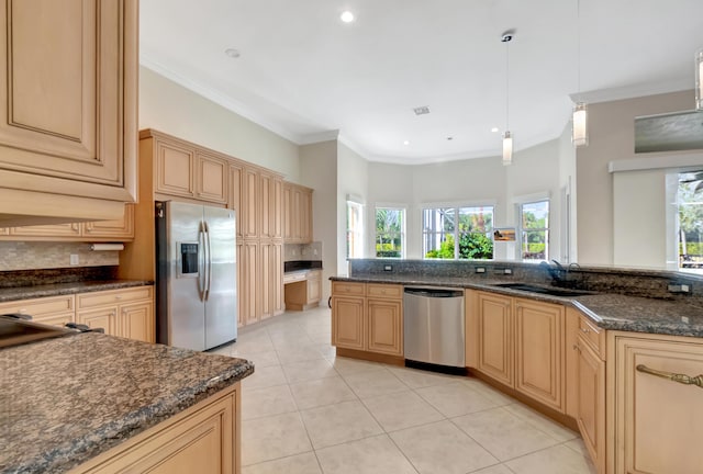 kitchen featuring sink, light brown cabinets, dark stone countertops, pendant lighting, and appliances with stainless steel finishes