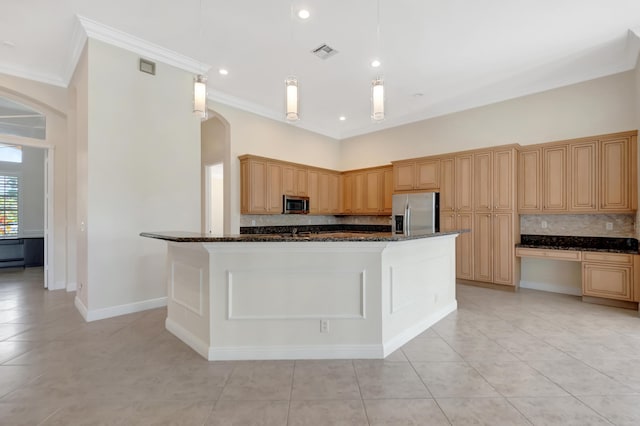 kitchen with appliances with stainless steel finishes, a center island with sink, light tile patterned floors, and dark stone counters