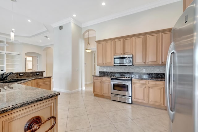 kitchen featuring sink, stainless steel appliances, tasteful backsplash, dark stone countertops, and pendant lighting