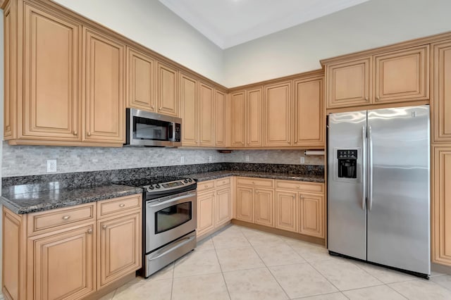 kitchen featuring dark stone counters, decorative backsplash, light brown cabinetry, light tile patterned floors, and appliances with stainless steel finishes