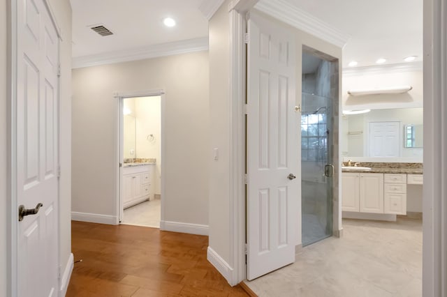 hallway featuring light hardwood / wood-style floors, ornamental molding, and sink