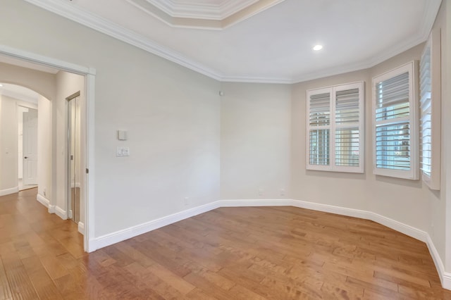 spare room with light wood-type flooring and crown molding