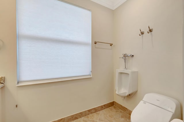 bathroom featuring toilet, tile patterned floors, and crown molding