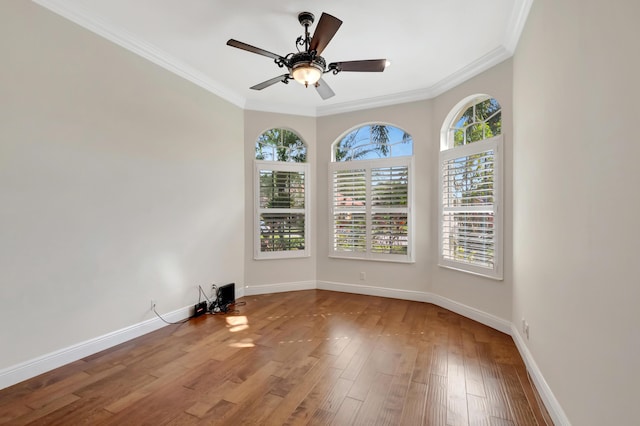 unfurnished room with ceiling fan, plenty of natural light, wood-type flooring, and ornamental molding