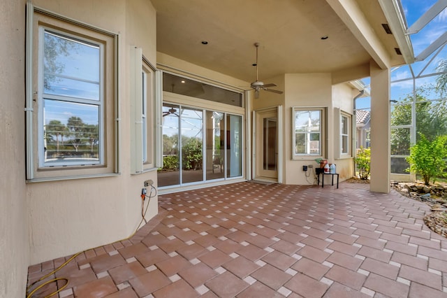 view of patio featuring glass enclosure and ceiling fan