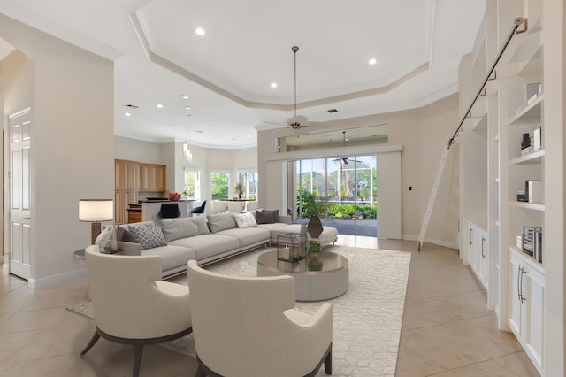 living room featuring built in shelves, a tray ceiling, light tile patterned floors, and ceiling fan