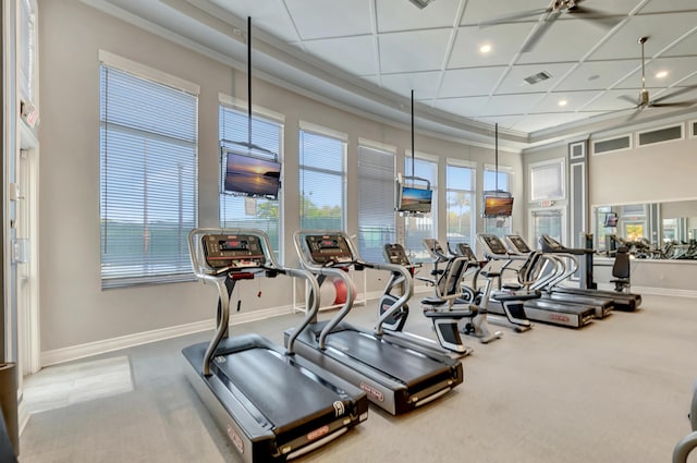 gym featuring ceiling fan, a high ceiling, and ornamental molding