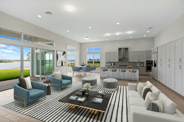 living room with sink, a healthy amount of sunlight, and a water view