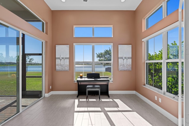 interior space with light hardwood / wood-style flooring and a water view