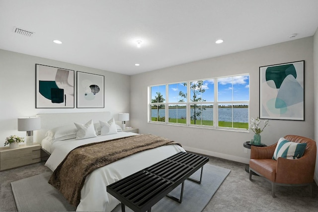 carpeted bedroom with a water view