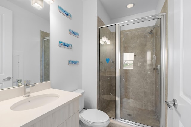 bathroom featuring an enclosed shower, vanity, and toilet