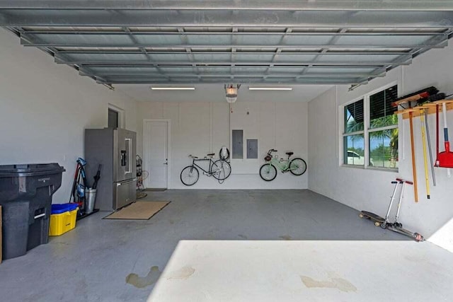 garage featuring a garage door opener, electric panel, and high end fridge