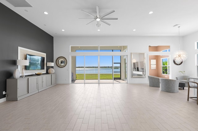 living room featuring ceiling fan with notable chandelier and plenty of natural light