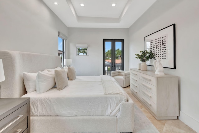 bedroom with access to exterior, french doors, and a raised ceiling