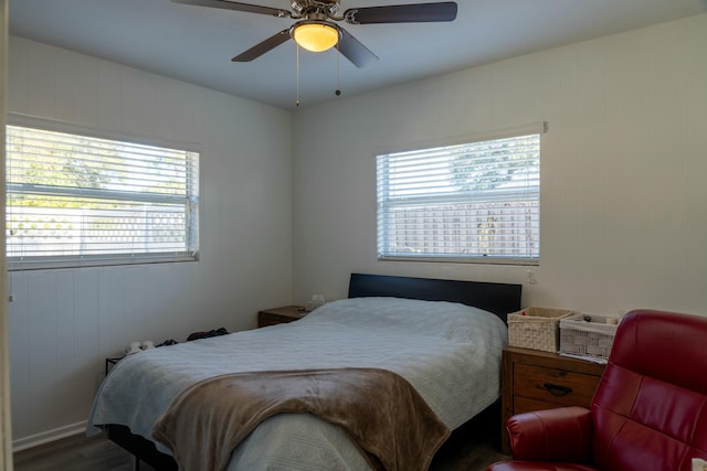 bedroom with hardwood / wood-style flooring, ceiling fan, and multiple windows