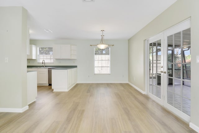 interior space featuring white cabinetry, a wealth of natural light, and decorative light fixtures