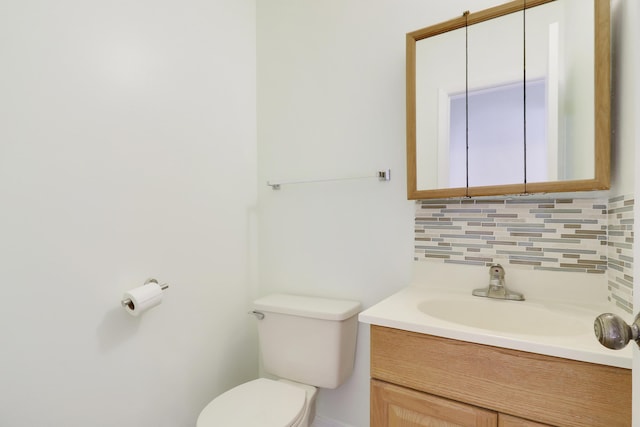 bathroom featuring vanity, toilet, and tasteful backsplash